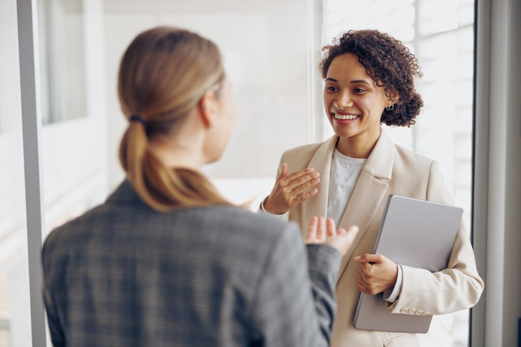 Happy diverse women office workers is distracted from work and talking in office during break